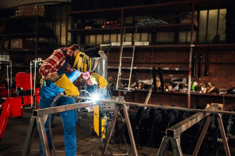 man welding metal with welding machine while wearing a protective gear.jpg